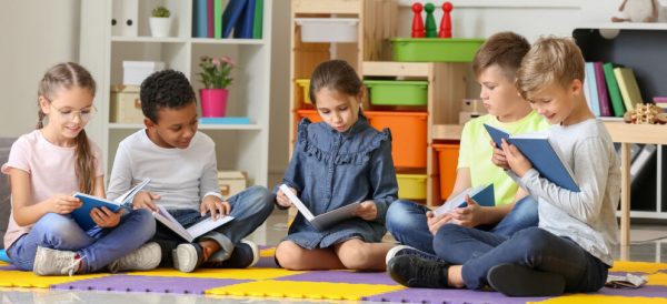 picture of four elementary age children reading at school